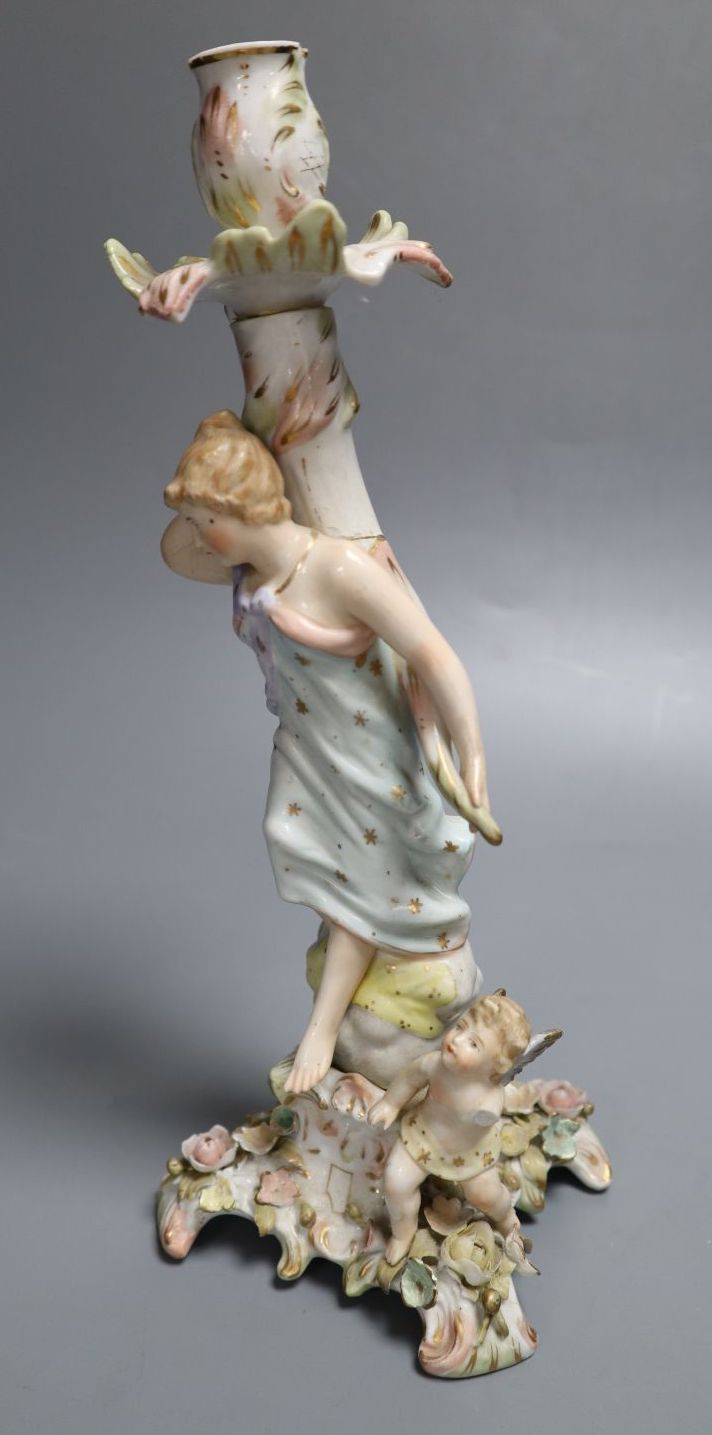 A German porcelain candlestick with lady and cherub, height 26.5cm (a.f.)